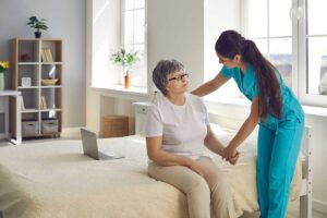 Nurse reviewing medications with an older resident at a dining table in an assisted living residence.